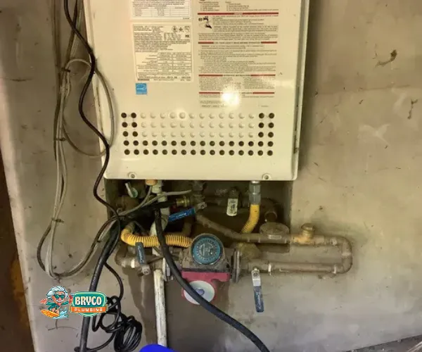 Close-up of a corroded copper pipe joint with heavy mineral deposits and green oxidation.