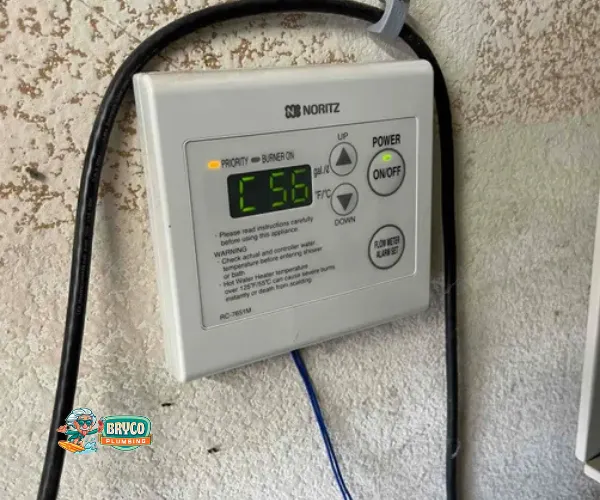 Section of copper plumbing with significant limescale buildup on threaded connections and valves.