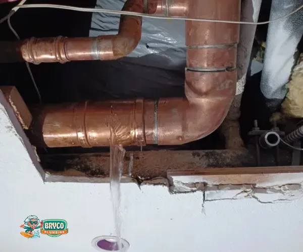 Corroded copper pipe joint with heavy mineral deposits and green oxidation.