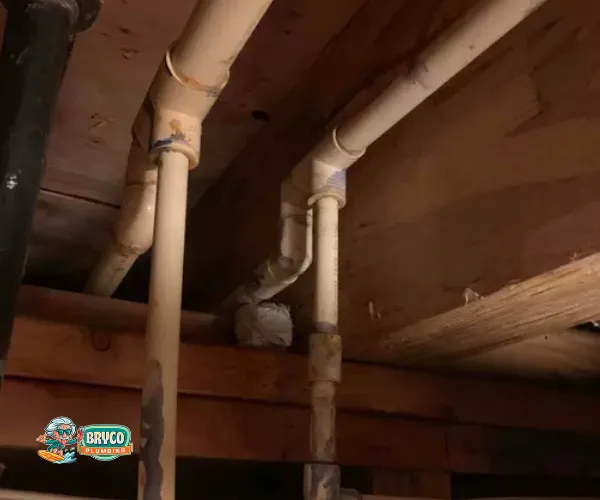 Close-up of a corroded copper pipe joint with heavy mineral deposits and green oxidation.